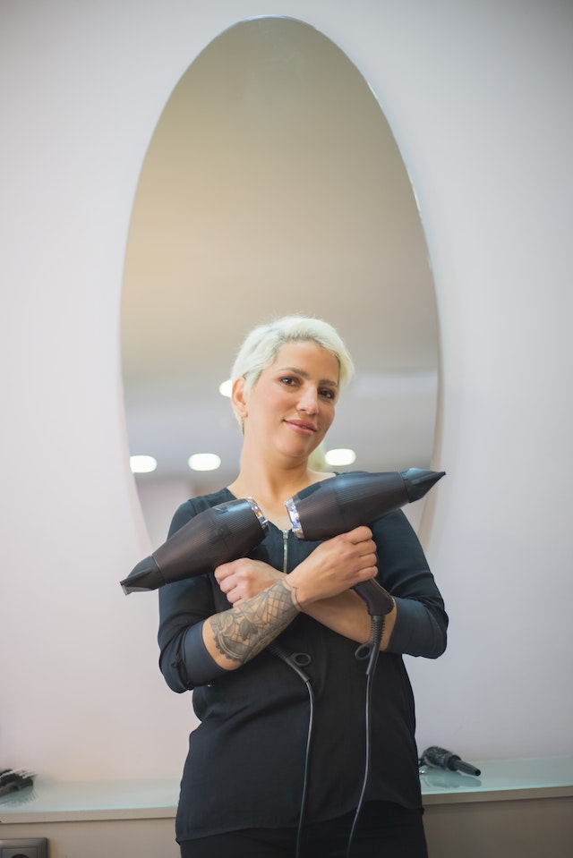 woman holding blow dryers